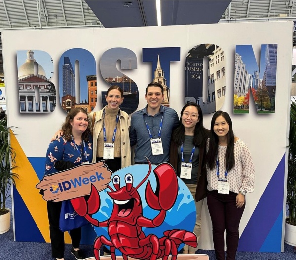 5 ID Fellows with banner of Boston in the background for IDWeek 2023