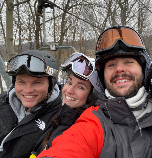Three smiling people wearing ski goggles and jackets