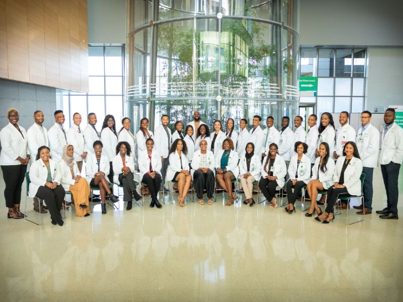 A group of diverse medical students wearing white coats