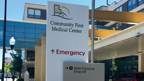 Exterior of Community First Medical Center. A sign in front of the building directs visitors to the emergency room and the main entrance drop-off.