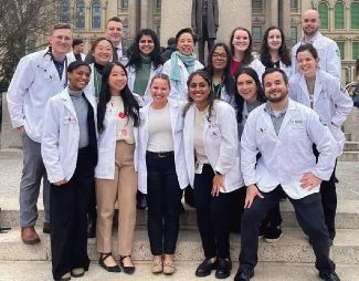 A group of people wearing white coats standing outdoors