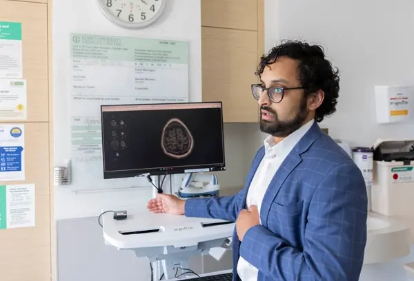 A researcher gestures to a computer terminal