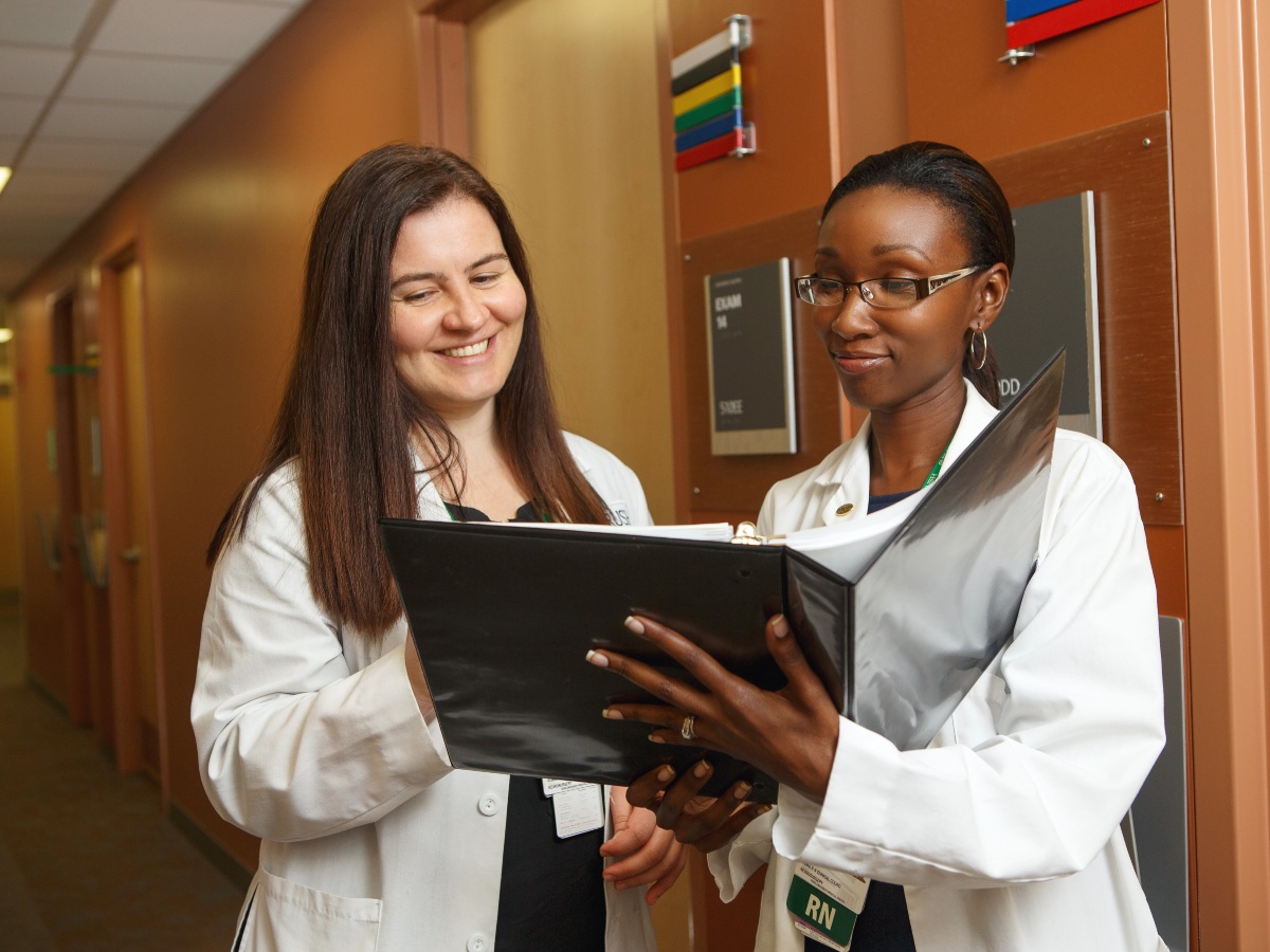 Two RNs look at information in a binder
