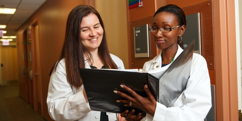 Two RNs look at information in a binder
