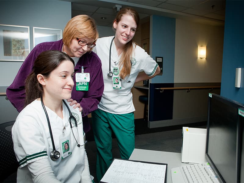 College of Nursing students working with a faculty member