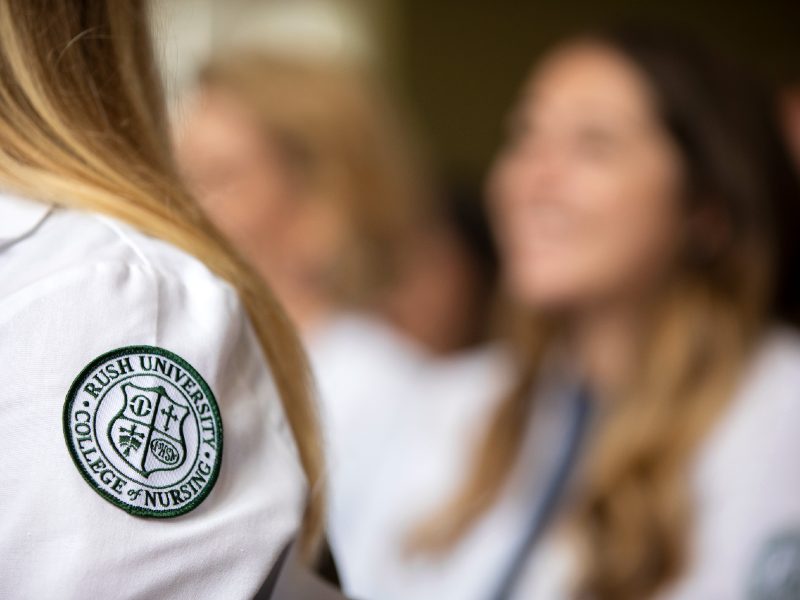 Close-up of a Rush University College of Nursing patch on the sleeve of a white coat