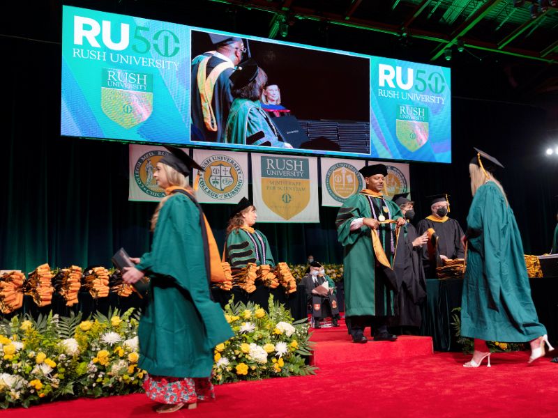 Graduates cross the stage during a commencement ceremony