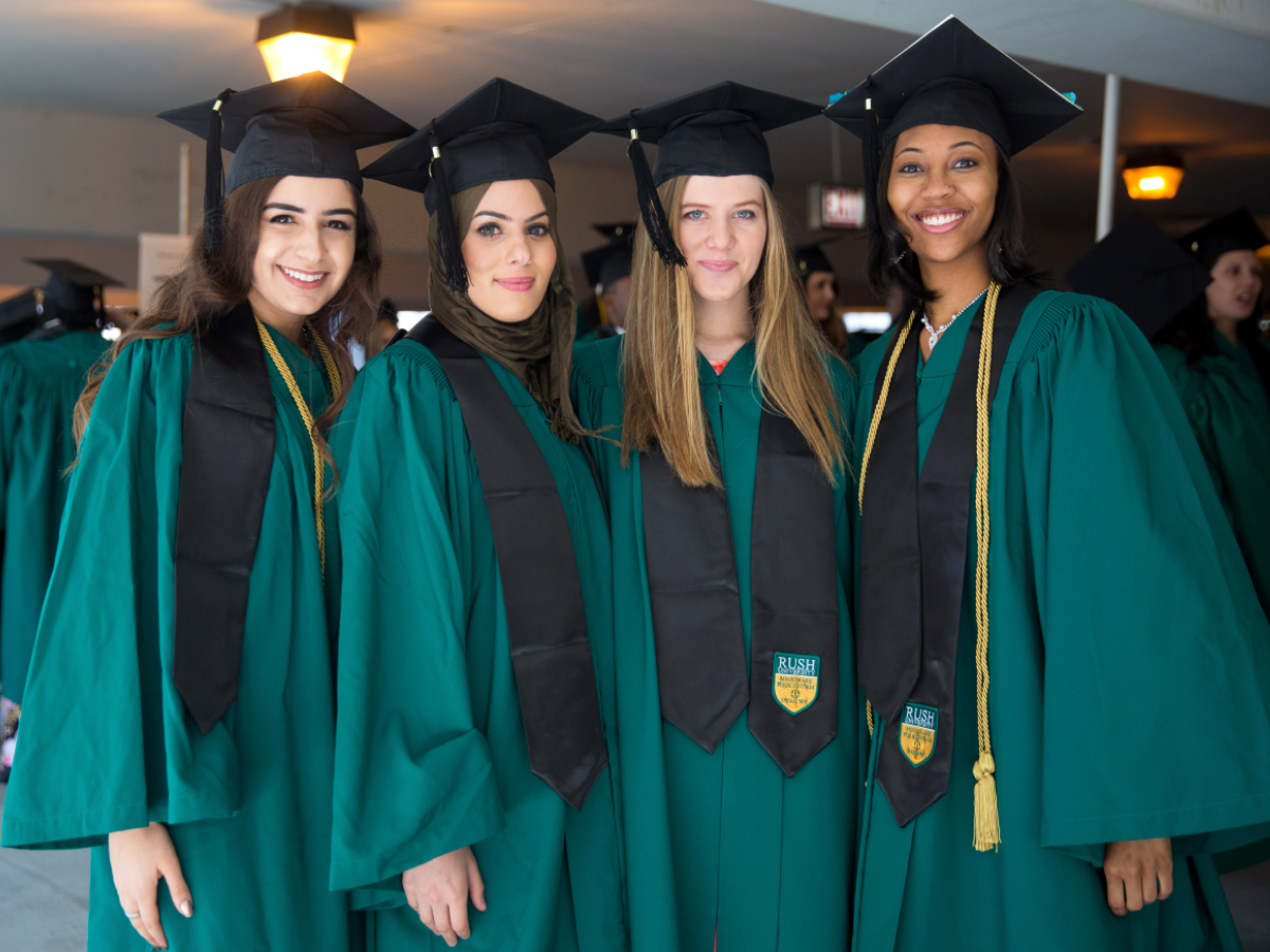Four graduates wearing commencement regalia