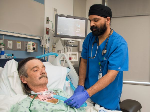 A respiratory therapist at a patient's bedside