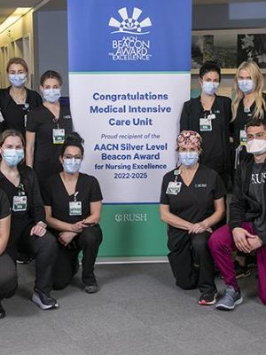 A group of nurses around a banner recognizing the Beacon Award