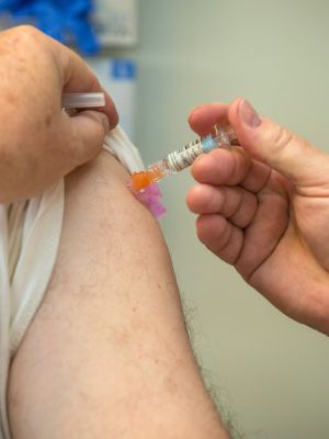 Flu shot being administered in a patient's upper arm
