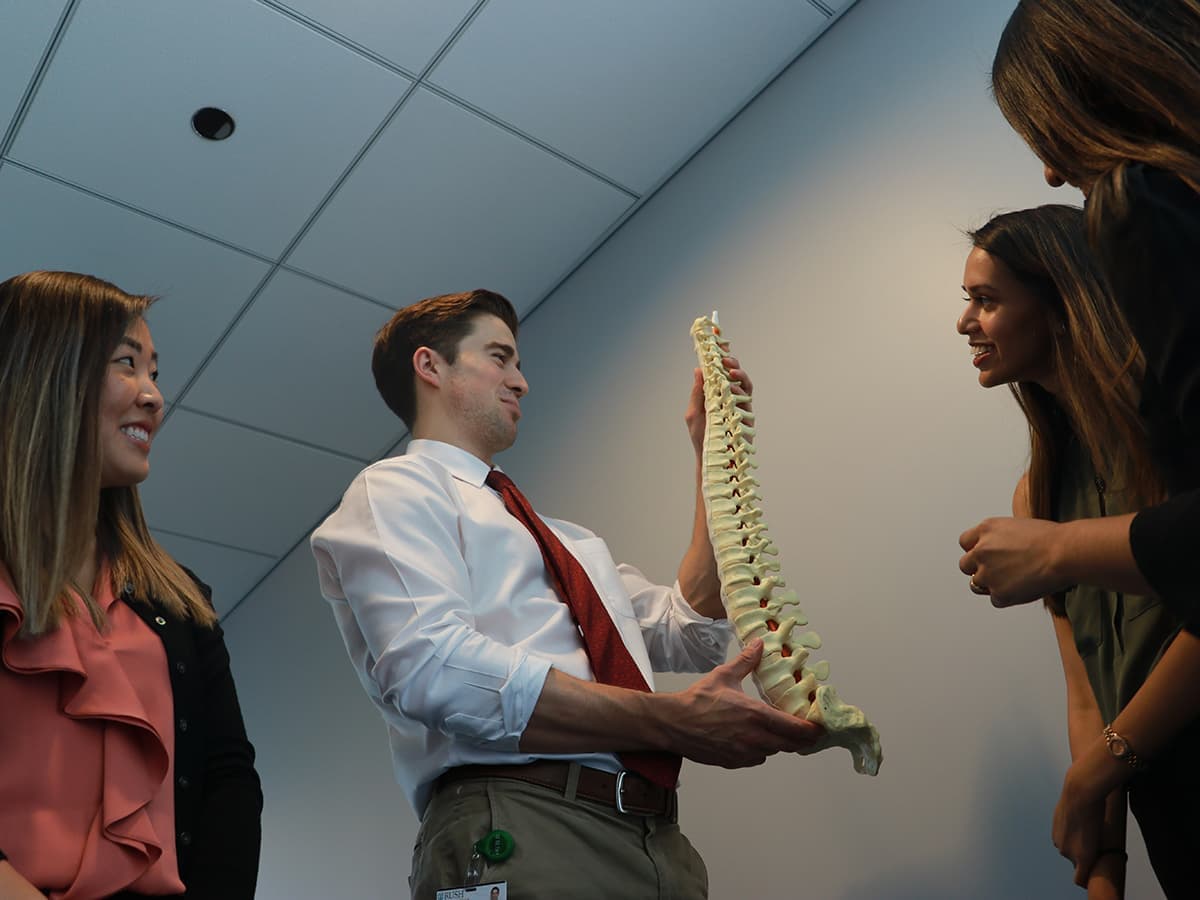 Rush student holding up model spine