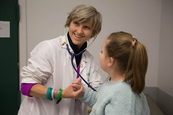 Rush faculty member using stethoscope on pediatric patient 
