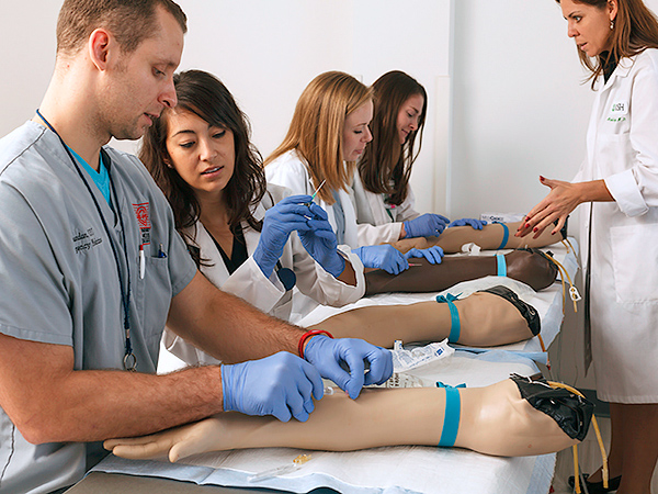 Medical students practice injections using prosthetic arms