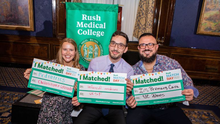 Three smiling students hold up signs that say I Matched! Rush Match Day 2022