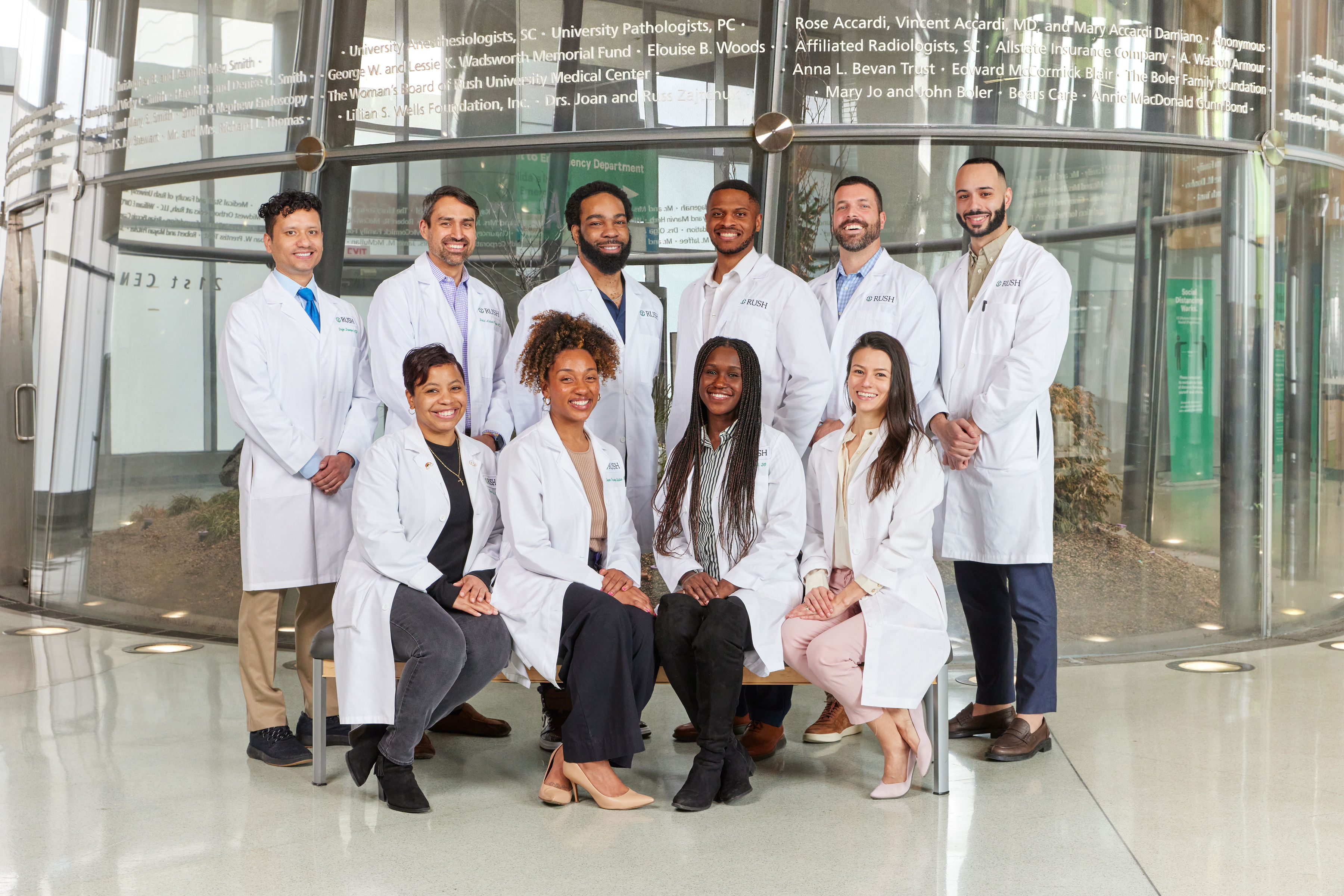 A diverse group of residents stand together in the RUSH University Medical Center Atrium.