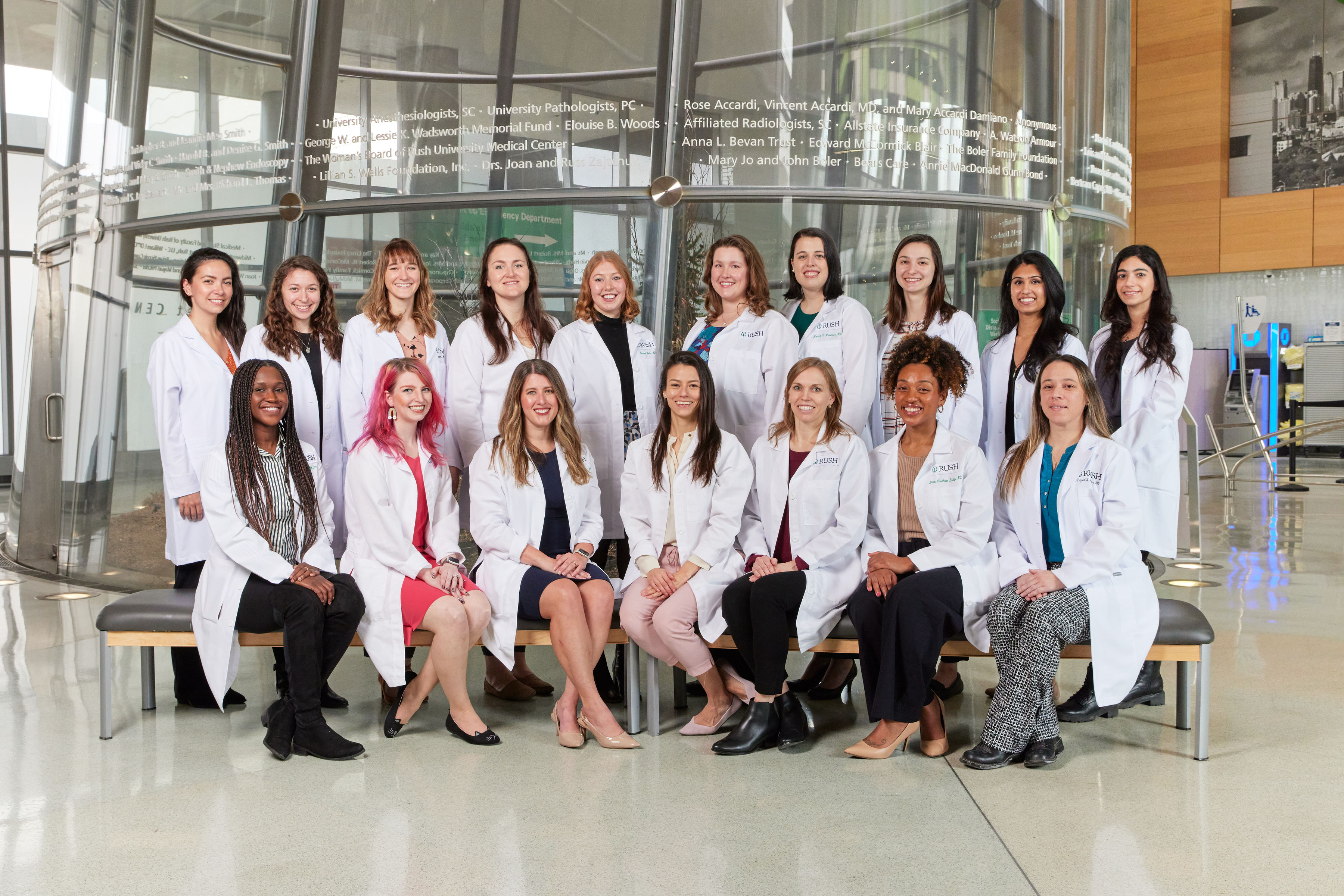 An all-women group of residents stand together in the RUSH University Medical Center Atrium.