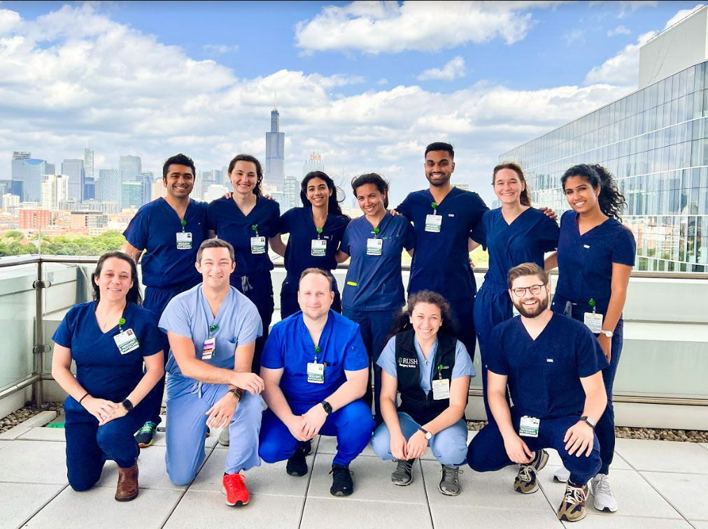 The class of 2025 poses on the RUSH rooftop garden with the Chicago skyline in the background.