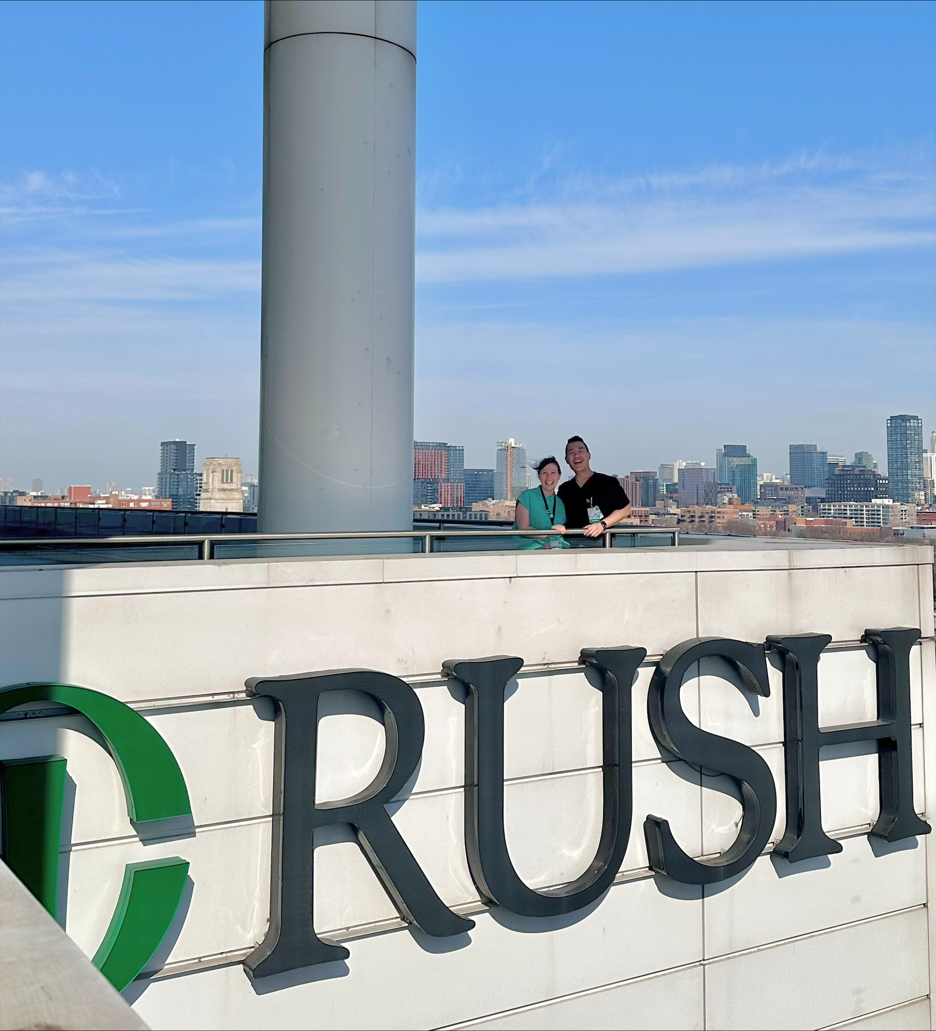 Two neurology residents posing atop Rush University Medical Center.