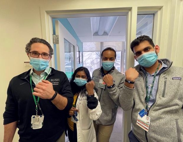 A group of doctors hold up their wrists to show fitness trackers