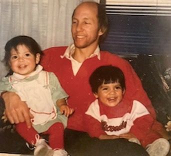 Vintage photo of a seated man holding smiling twin babies