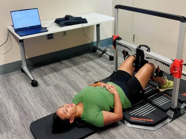 Research participant lying on the floor using exercise equipment