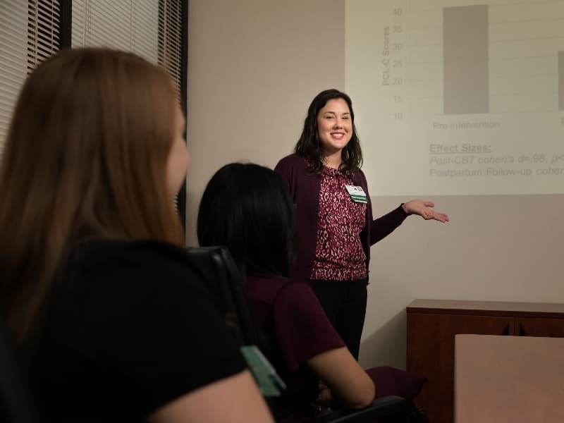 A woman doctor speaks in front of a group.