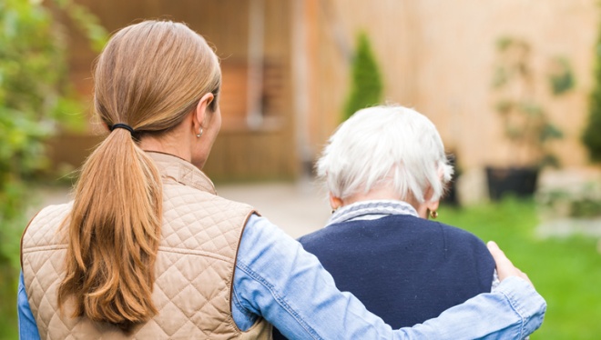 Young woman with her arm around a senior.