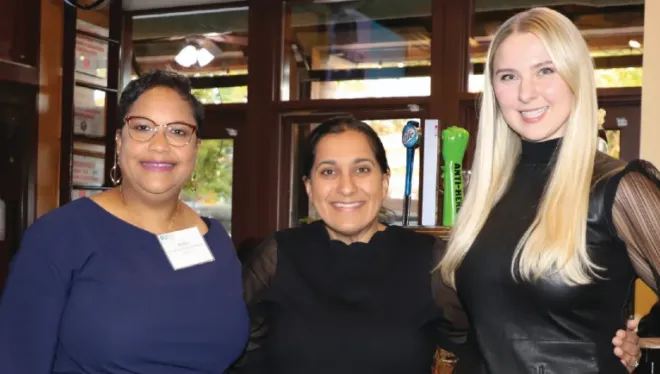 Three people smiling for a photo at an event