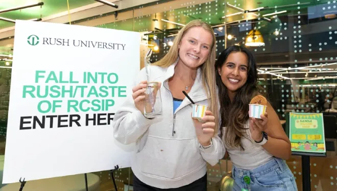 Two students holding ice cream treats and smiling