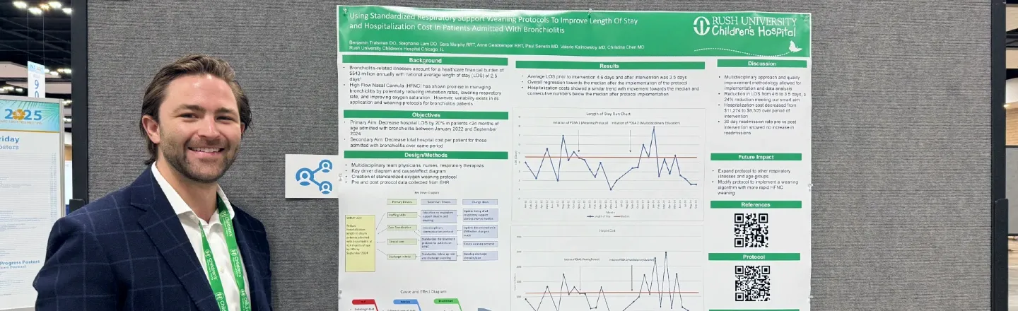 A researcher stands beside a poster