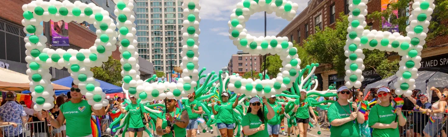 Marchers in a parade holding up balloon letters spelling out RUSH