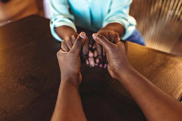 two people holding hands across a table