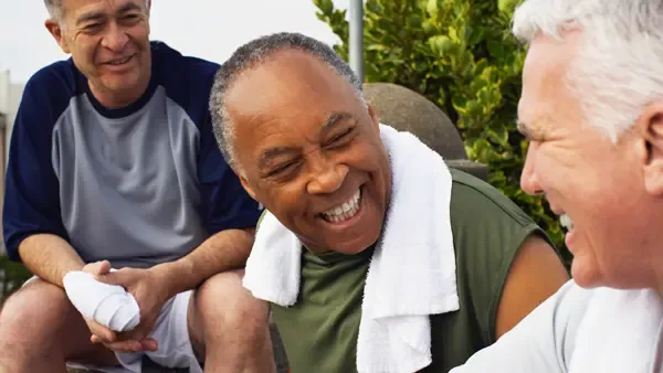 Three smiling men taking a rest after exercising