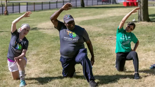 Three people stretching on grass