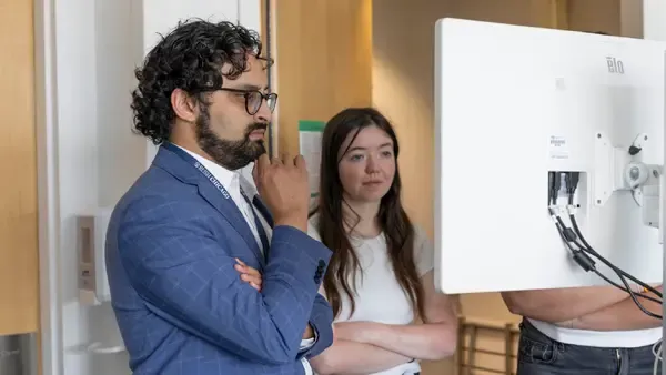 Arka Mallela, MD, MS, looks at a brain mapping computer screen with a woman in the Rush Center for Brain Mapping
