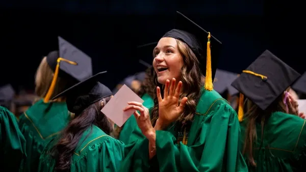 A graduating student looking up with an expression of suprise and excitement