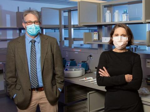 Drs. Stefan Green and Mary Hayden wearing masks standing in a lab