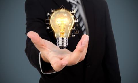Person with an outstretched hand with an image of a shining lightbulb over the hand