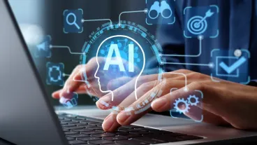 Close-up of hands typing at a laptop keyboard, with AI and symbols representing technology overlaid