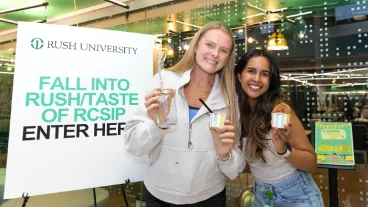 Two students holding ice cream treats and smiling