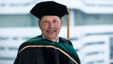 Robert Balk, MD, smiles in his regalia as university marshal.