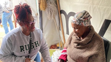 Aisha Ealey, DNP, APRN, cares for women and babies across the world. She is wearing a gray Rush University College of Nursing crewneck.
