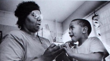 Dorie Burrell teaches young child how to use a device that measures lung capacity in 1994.