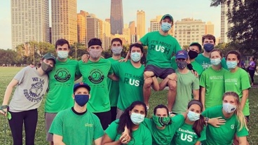 A group of residents wearing RUSH t-shirts pose together in a park