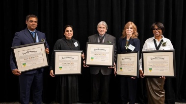 Five people holding framed award certificates