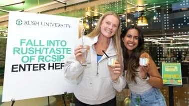 Two students holding ice cream treats and smiling