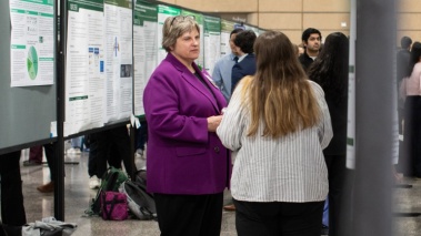 Debbie Martin, PhD, Provost, Rush University speaks with a student during poster presentations.