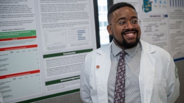 College of Nursing student smiles in front of their capstone presentation