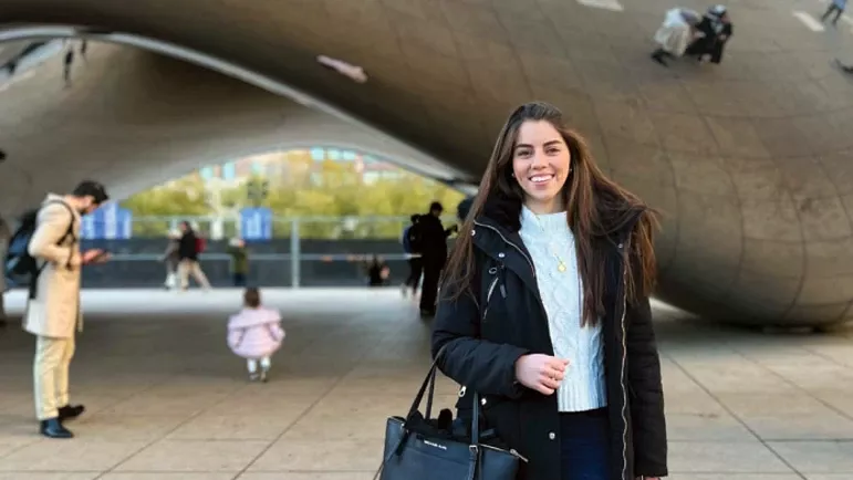 Student Victoria Gonzalez stands in front of Chicago's Cloud Gate sculpture, commonly known as the Bean